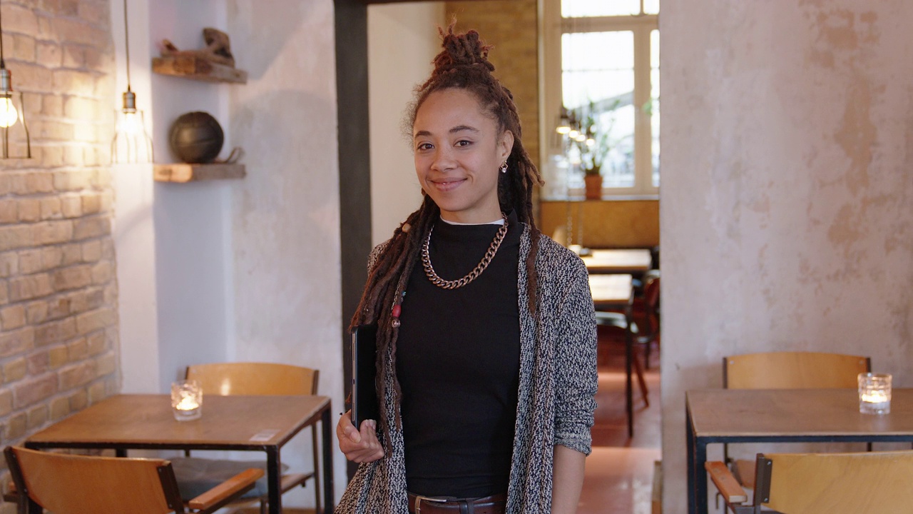 一个年轻的女商人站在咖啡馆里的肖像视频下载