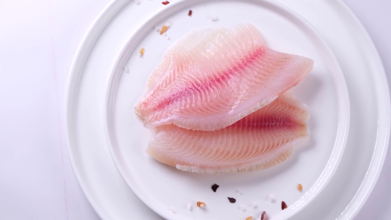 鱼柳或其他海鱼的特写，与香料和盐放在盘子里视频下载