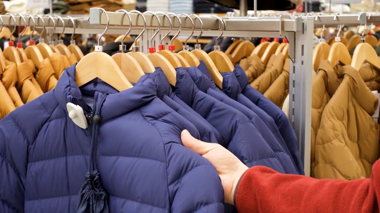 男士在服装店的特写镜头中挑选彩色夹克。视频素材