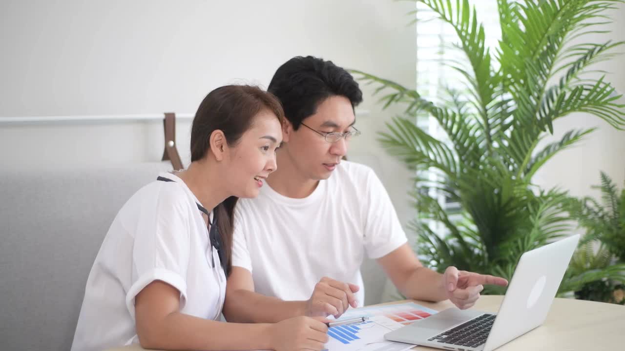 兴奋的亚洲夫妇使用笔记本电脑，获奖者视频素材
