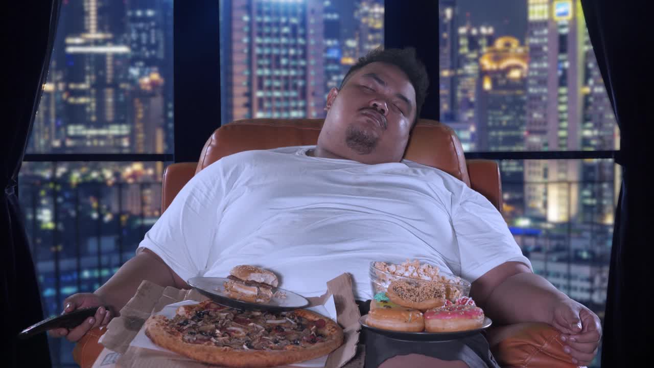 一个胖子在公寓里吃垃圾食品睡觉视频下载