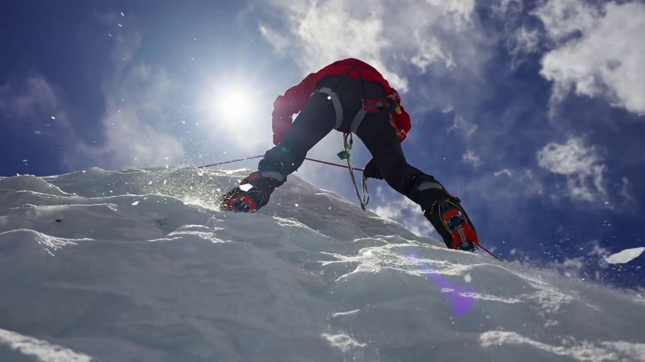 装备登山者攀爬冰墙。水晶碎片从上面落下视频下载