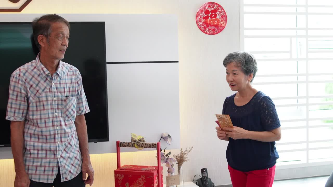在中国农历新年期间，亚裔中国活跃的老年女性给家人发红包视频下载