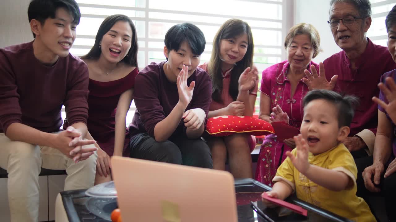 春节期间，亚洲华人通过笔记本电脑在客厅进行多代家庭视频会议视频下载