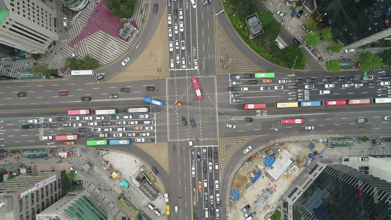韩国首尔江南区德黑兰路附近的摩天大楼和江南站交叉路口行驶的汽车视频下载
