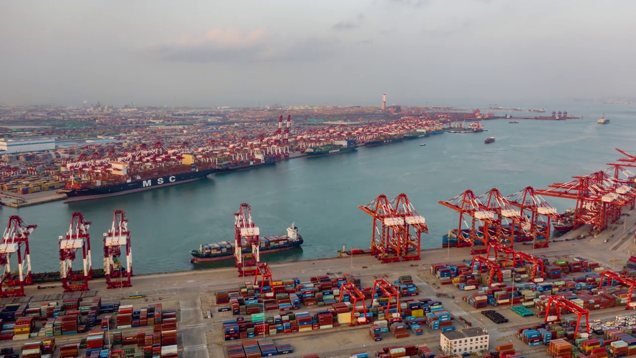 快速运动时间推移。中国山东省青岛市码头商港、商业物流和运输业集装箱货轮无人机航拍视频素材