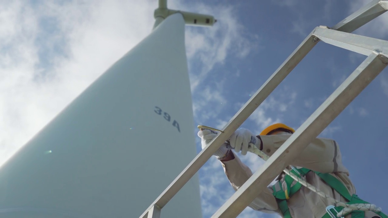 专业技术人员工业攀爬在风力涡轮机工作。视频素材