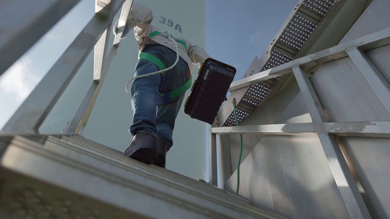 专业技术人员工业攀爬在风力涡轮机工作。视频素材