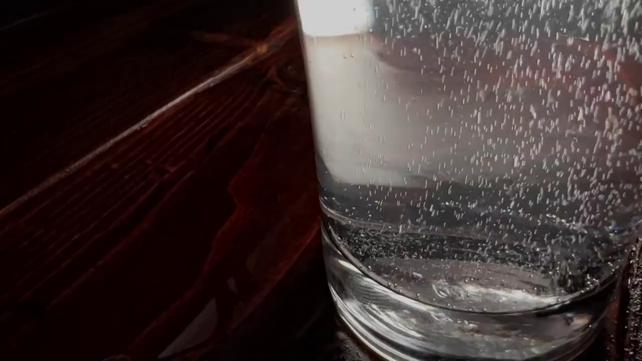 在清澈的小玻璃杯里冒着泡，背景是黑色的视频素材