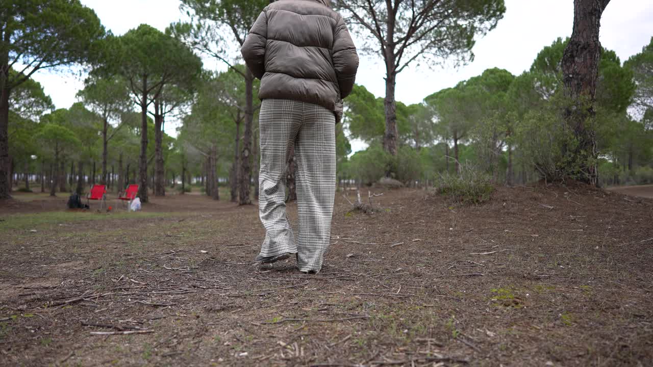 一个女人和她的狗在森林的冬天散步。视频下载