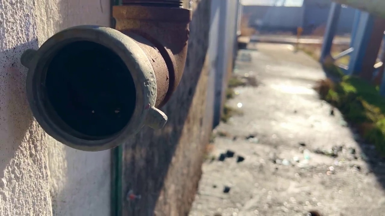 打开附在旧钢建筑物上生锈的管子视频素材