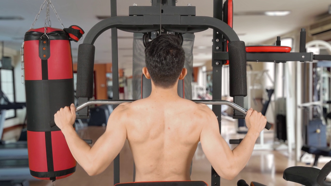 男子在健身中心的健身器材上锻炼视频下载