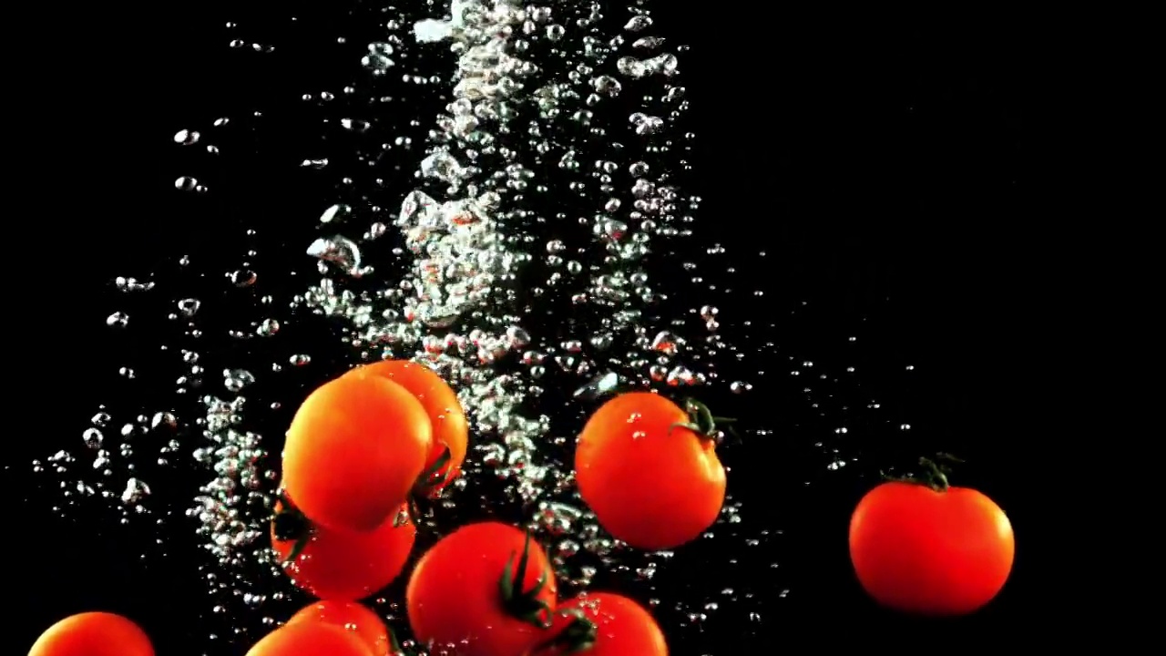 新鲜的西红柿带着气泡落在水里。拍摄的是慢动作每秒1000帧。视频素材