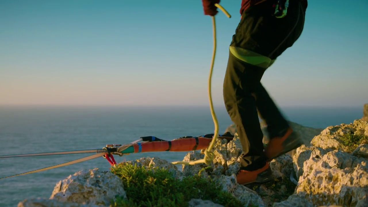 一个高空冒险家把背带系在悬崖顶上的一根绳索上视频下载