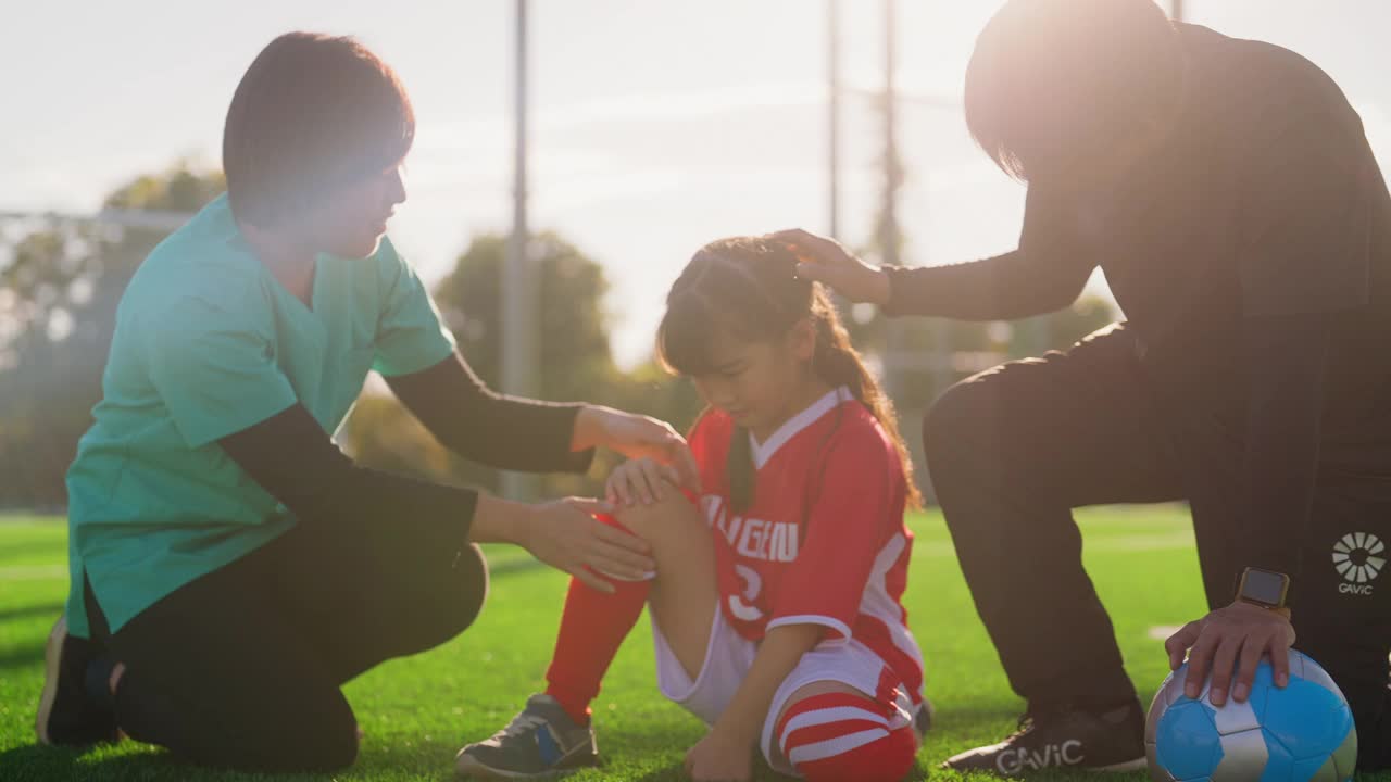 护士检查小学女生足球或足球运动员的伤势视频下载