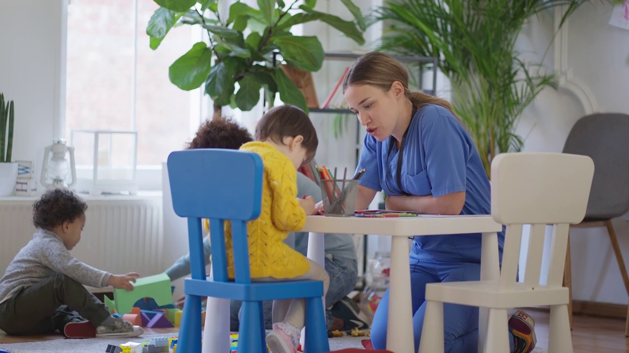 在儿科诊所，儿科护士在和小女病人玩耍视频素材