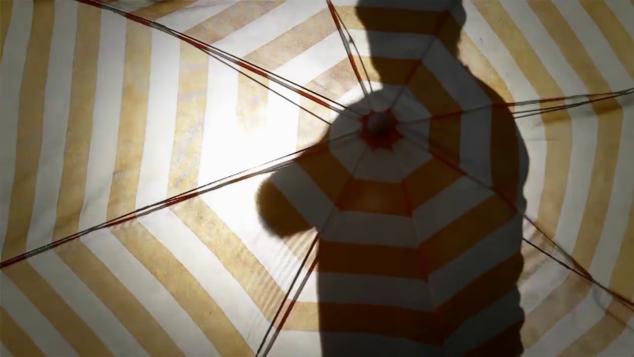 一名男子在户外打开沙滩伞，4K分辨率。视频素材