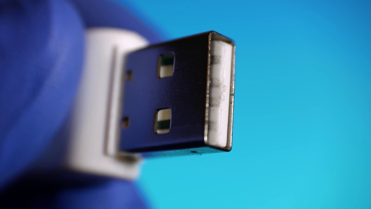 u盘记忆卡的特写是在蓝色背景的蓝色手套视频下载