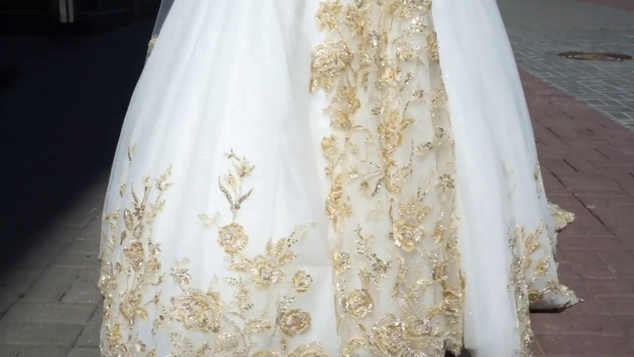 新娘穿着金色绣花裙走在街上视频下载
