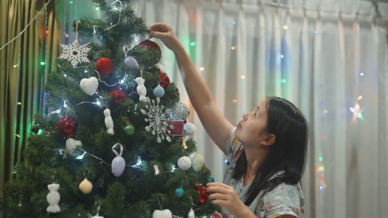 在家装饰圣诞树的快乐女人。视频下载