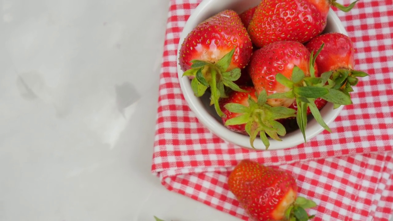 新鲜的草莓。芬芳的草莓在灰色的背景上。红色餐巾上的草莓。灰色的背景。视频素材