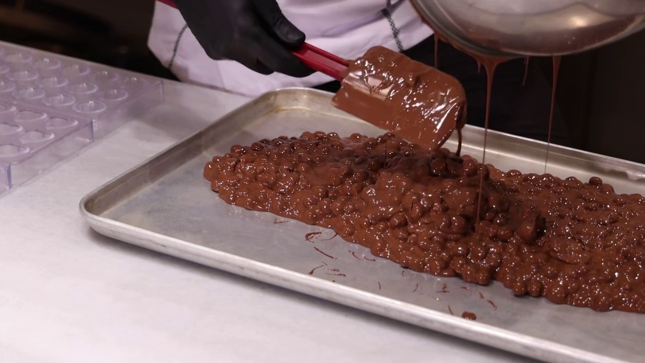 一位厨师正在往模子里倒巧克力。视频下载