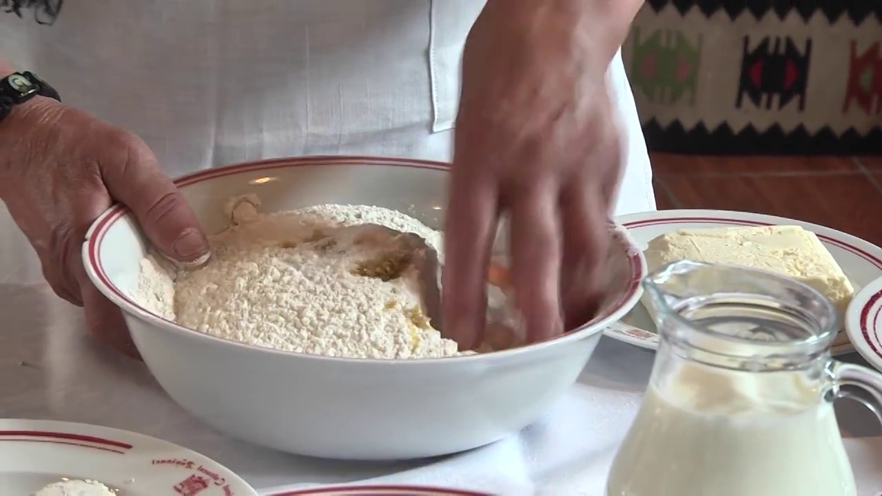 厨师在碗里准备蛋糕面团，在面粉和蛋黄上放几汤匙糖，然后混合视频下载