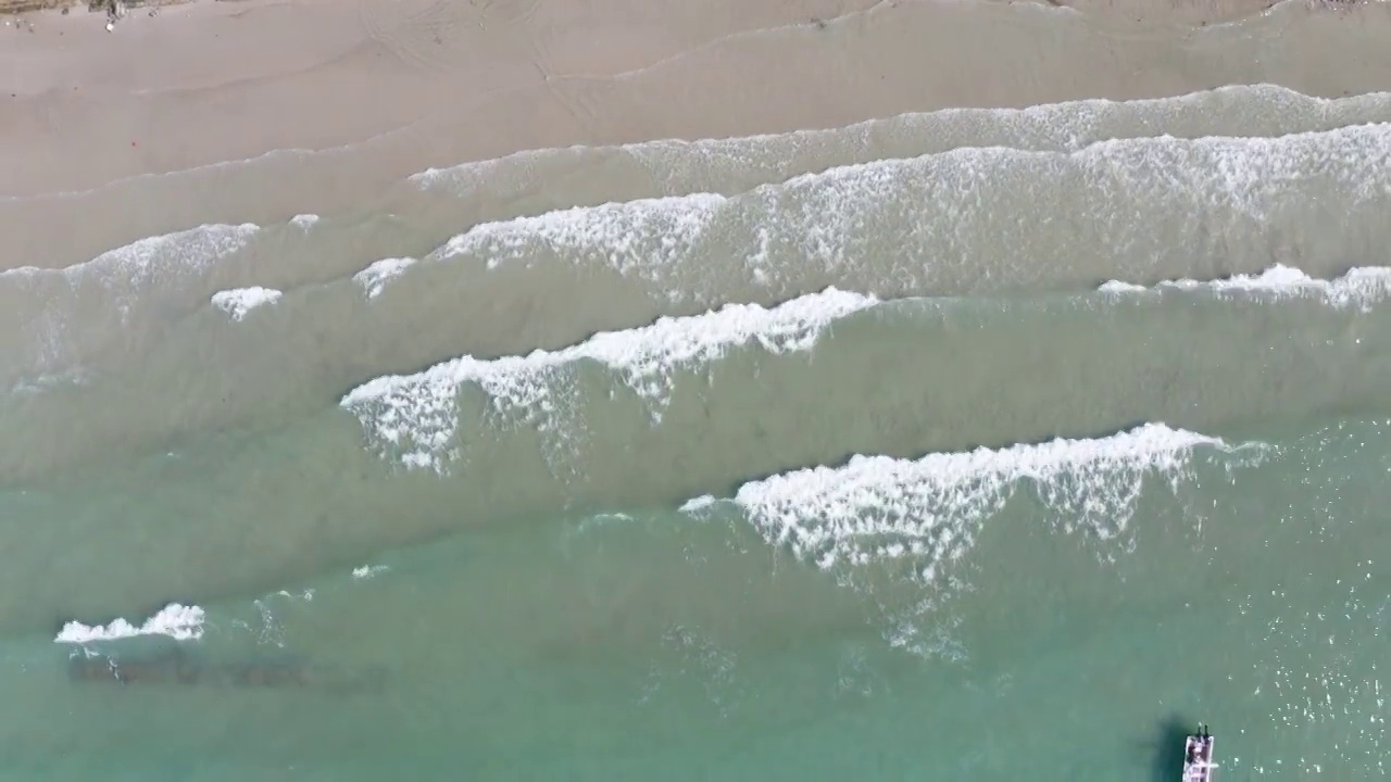 拍摄蓝色的水和白色的浪花从上面流向岸边视频下载