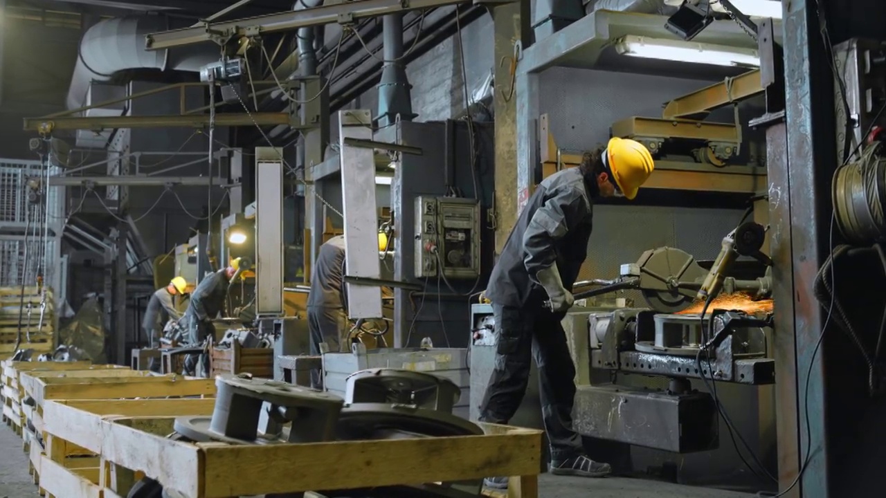 男工人在铸造车间对金属铸件进行抛光视频素材