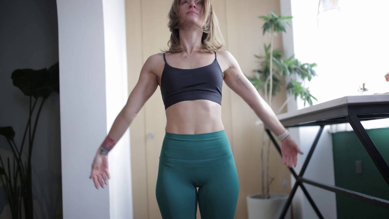 年轻的白人母亲穿着瑜伽裤在家锻炼视频素材