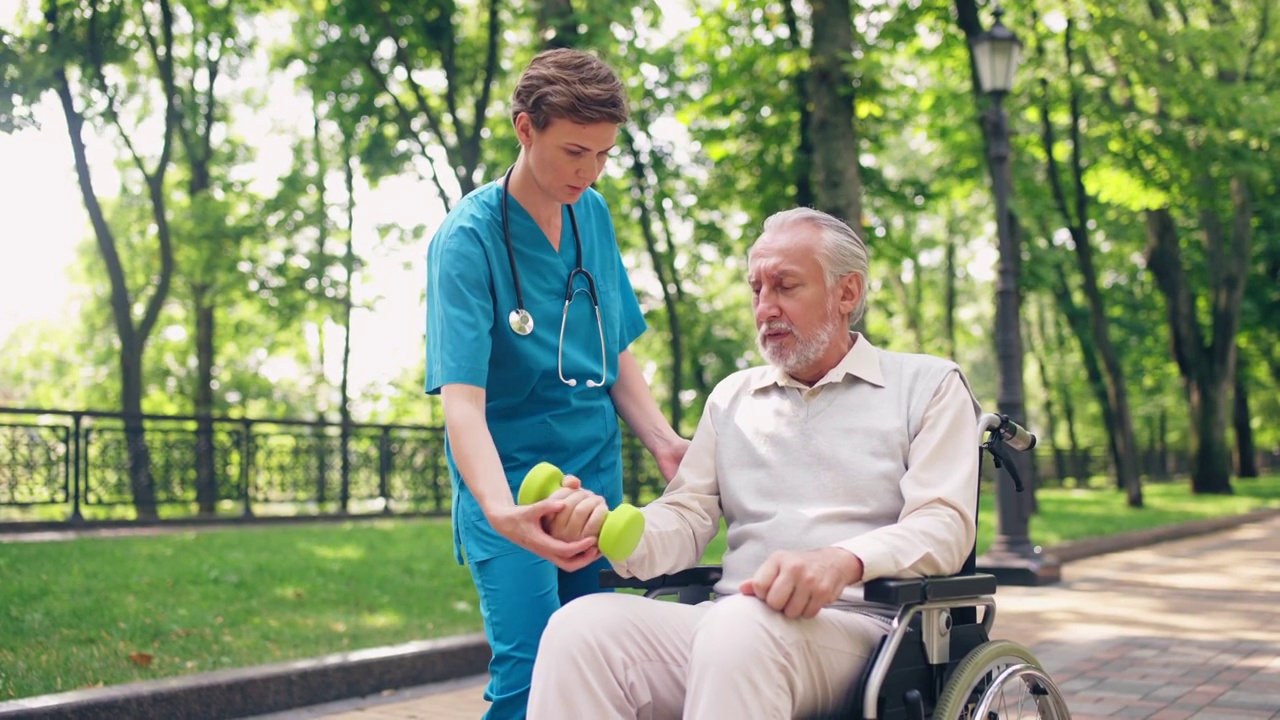 康复专家帮助老人做哑铃运动，恢复健康视频下载