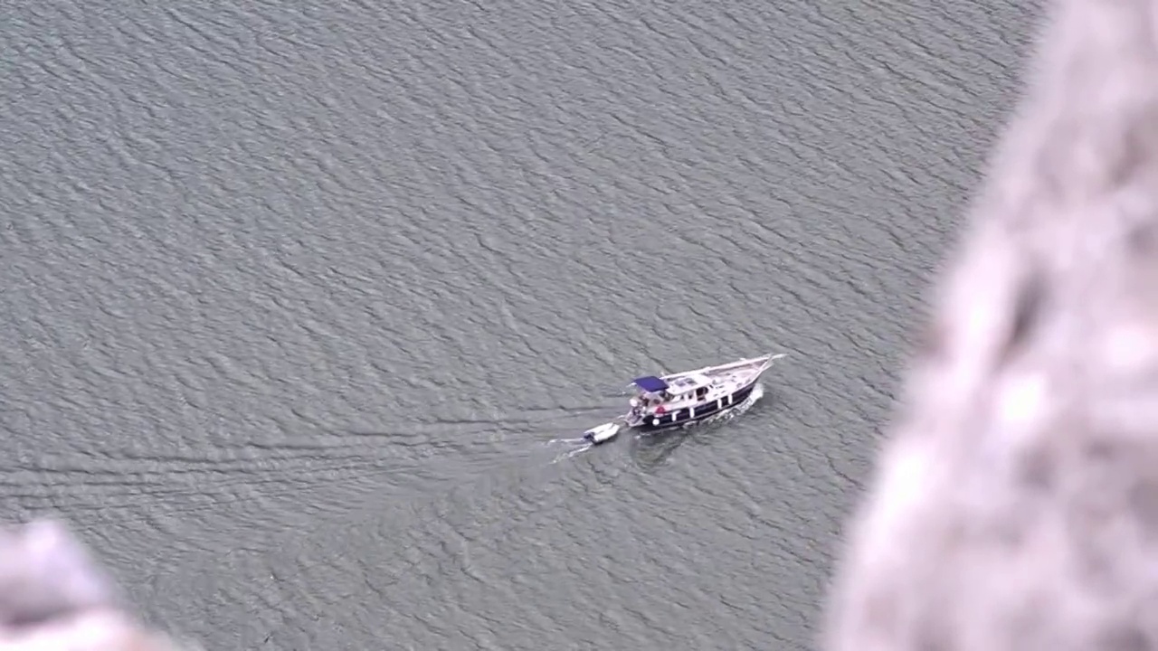 在河上的一些岩石上可以看到一艘蓝色的船，它正在追赶她的救援船视频下载