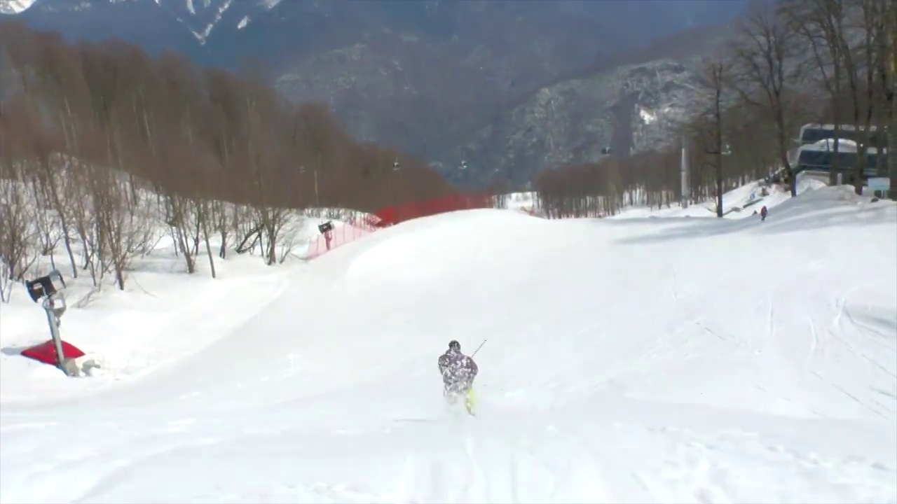 滑雪者在冬天的雪山上跳跃和做720个旋转特技。视频下载