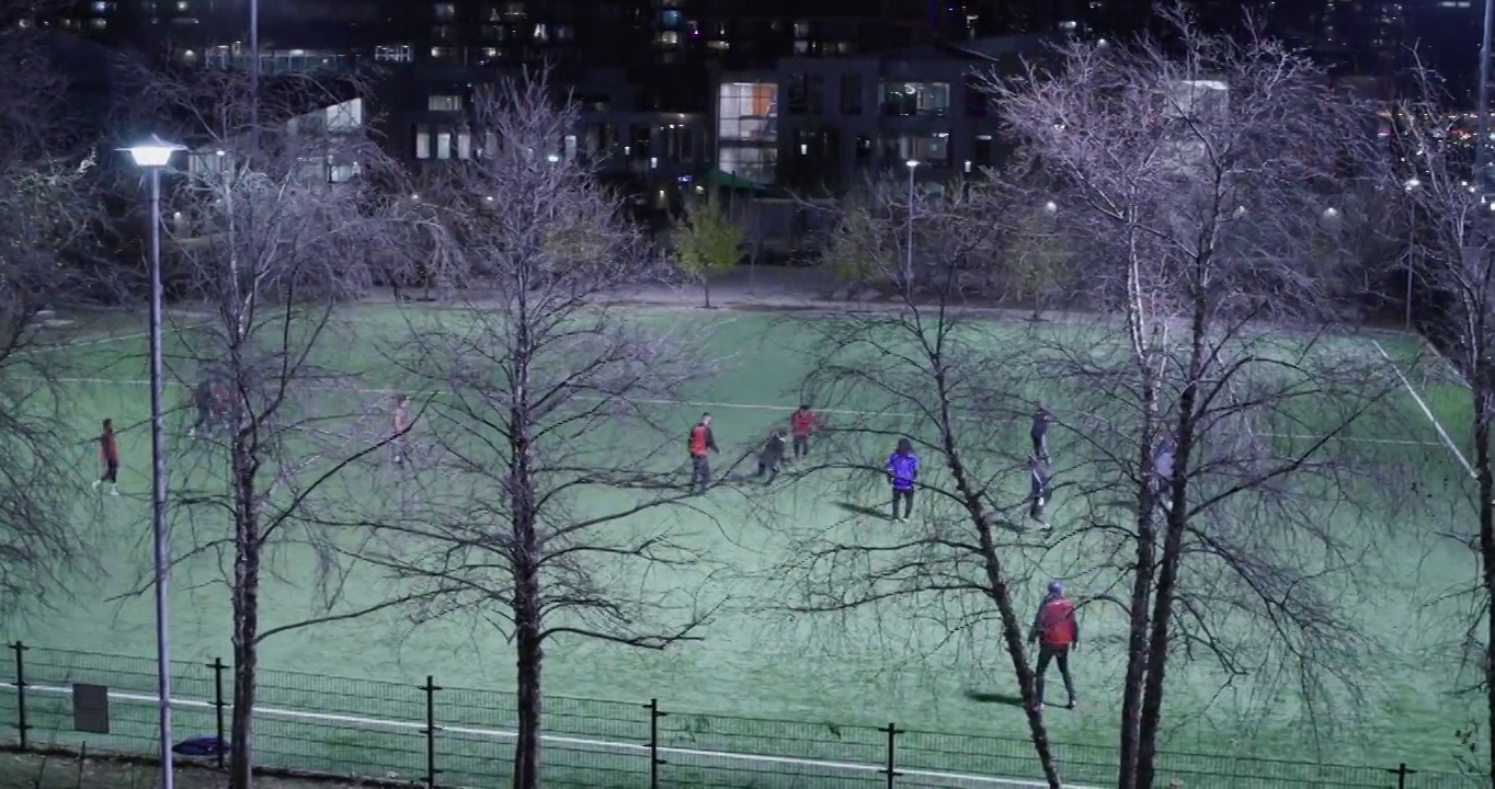 人们晚上在公共运动场踢足球视频素材