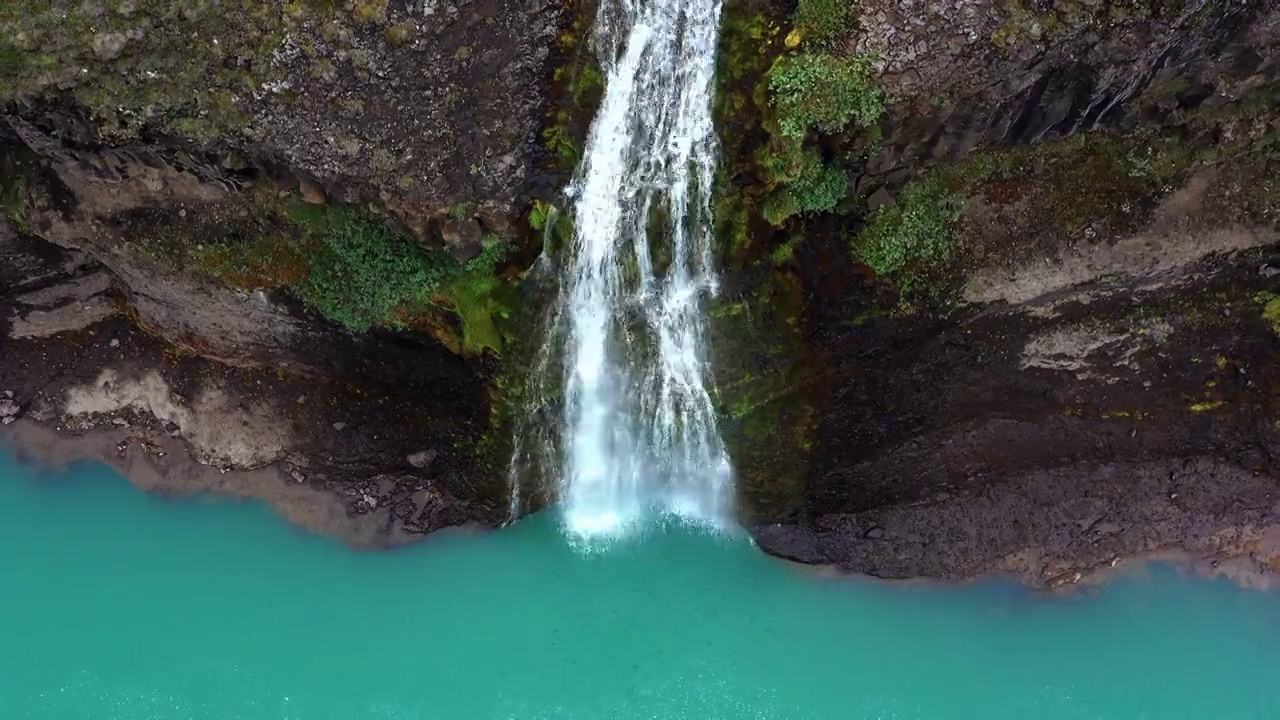 航拍视频显示，冰岛，瀑布倾泻入色彩鲜艳的河水中视频下载