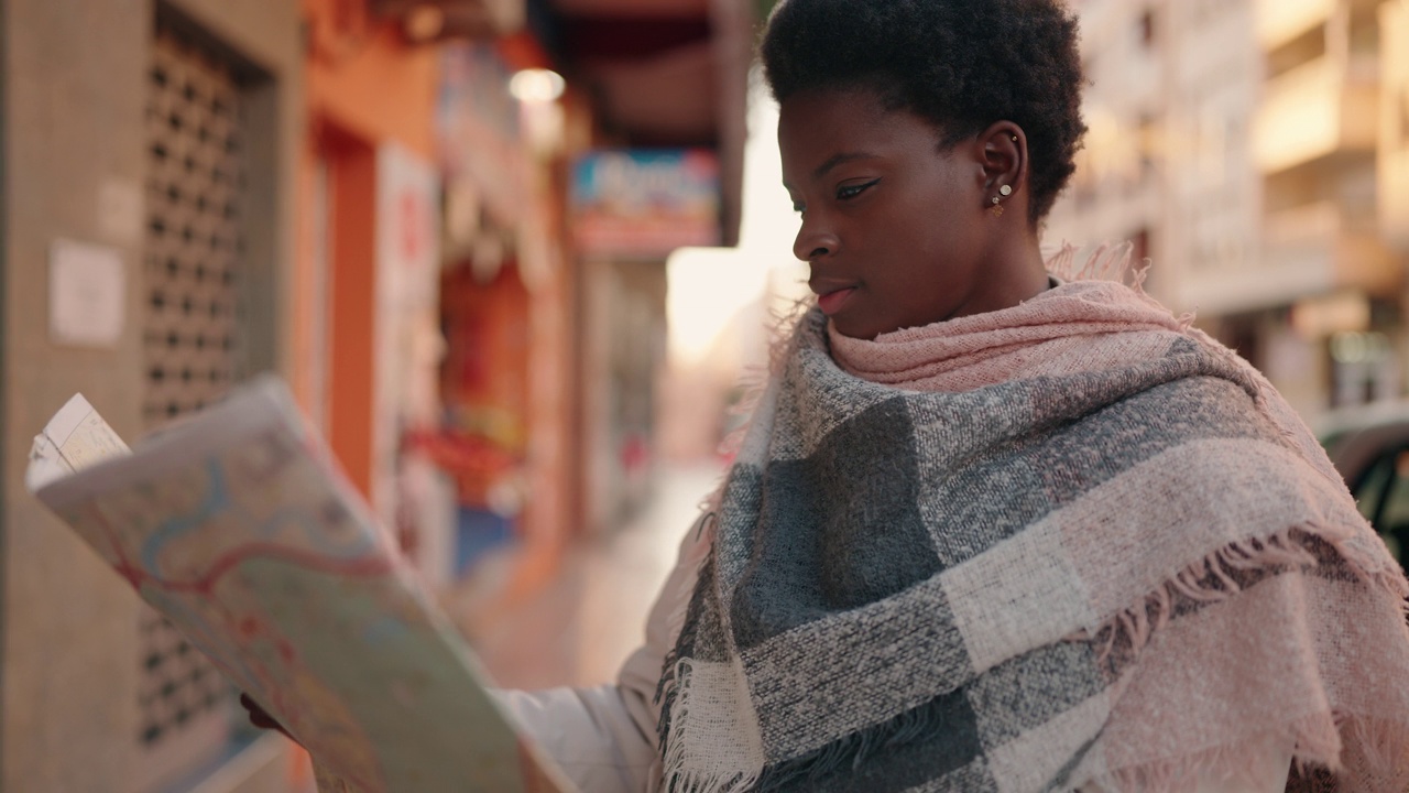 年轻的非洲裔美国妇女在街上看城市地图视频下载