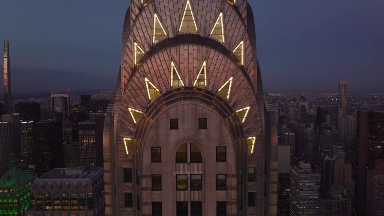 拉回镜头的照明装饰皇冠上的高层克莱斯勒大厦。摩天大楼在黄昏。曼哈顿，美国纽约市视频下载