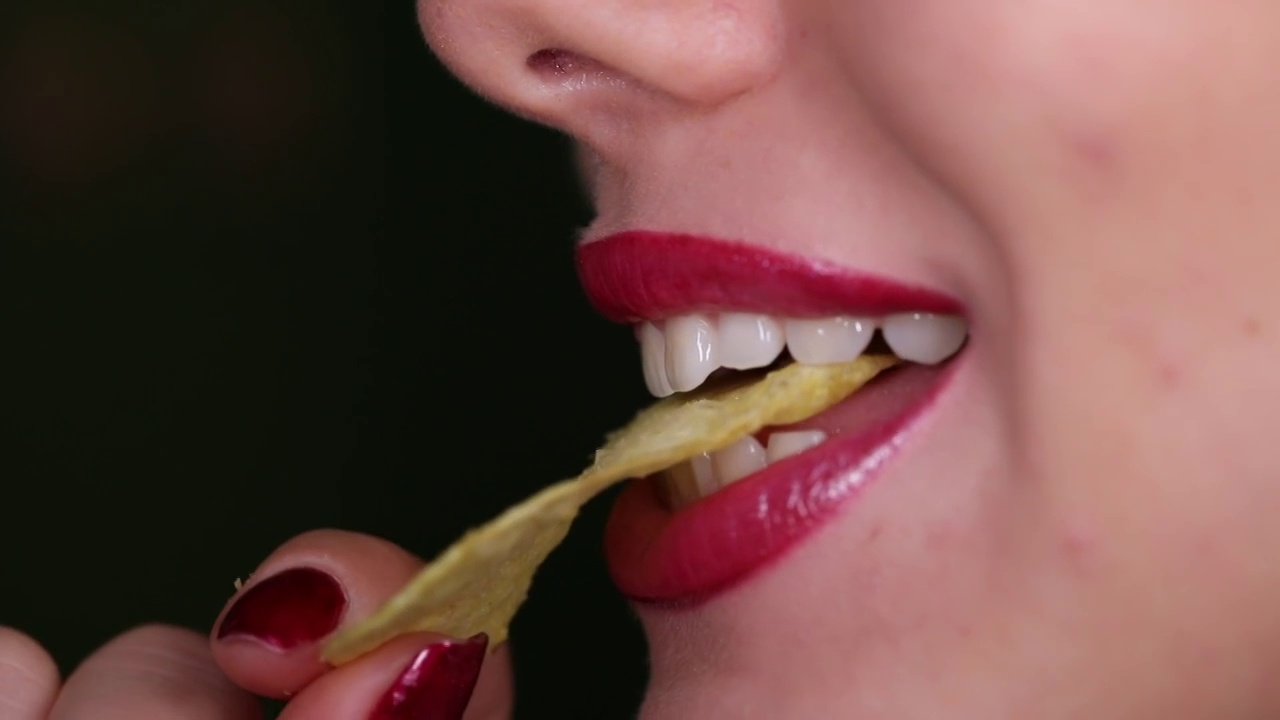 女性牙齿咬着薯片视频下载