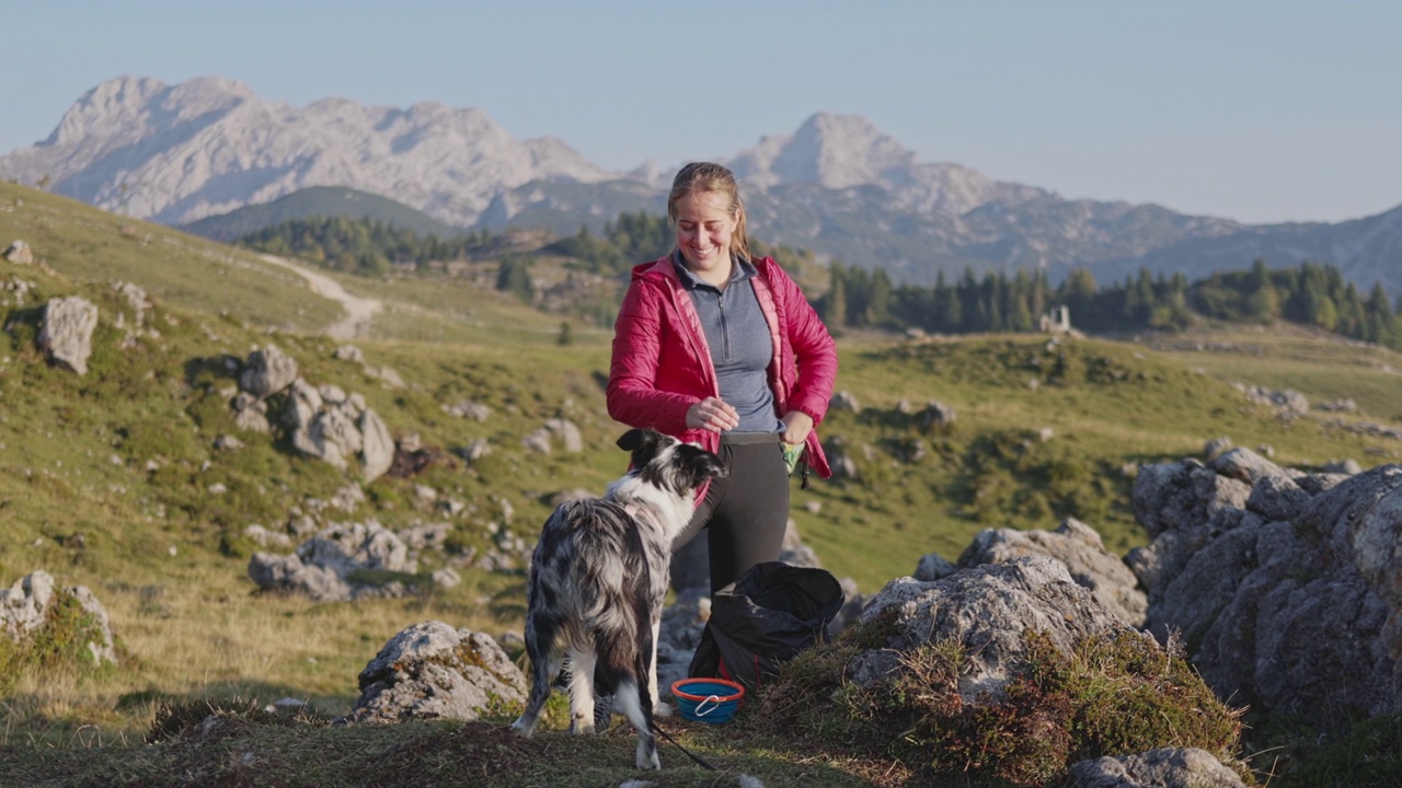 年轻女子和宠物狗在山上的肖像视频素材