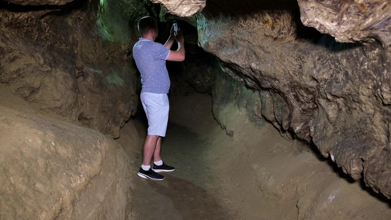 一个游客在地下城的洞穴里拍照。视频素材