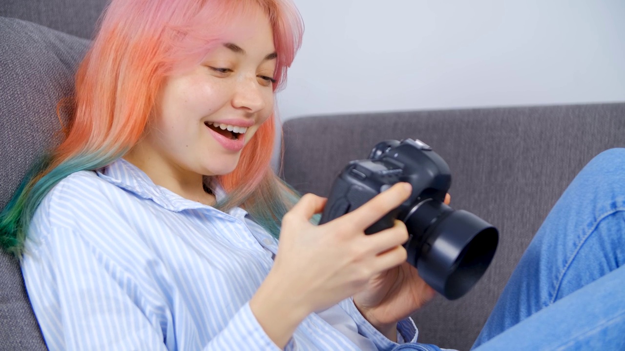快乐的白人女孩带着相机。美丽的白人年轻女子在20多岁浏览照片的专业数码单反相机与哇表情视频素材