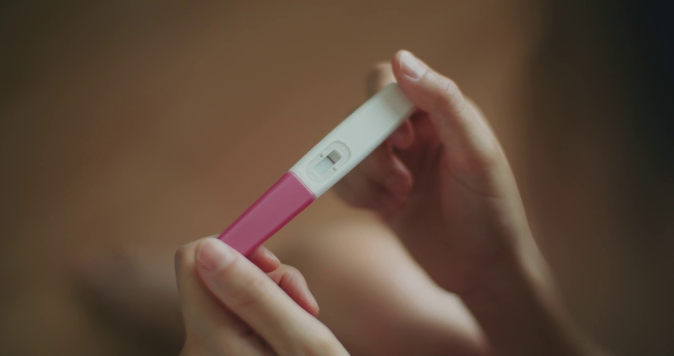 在家里做了怀孕测试后，一名悲伤的年轻女子看起来很沮丧视频下载