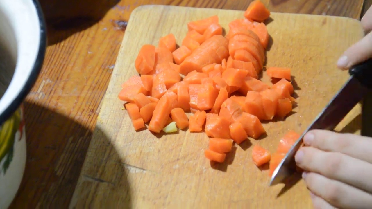 用刀在厨房的砧板上切熟的胡萝卜视频素材