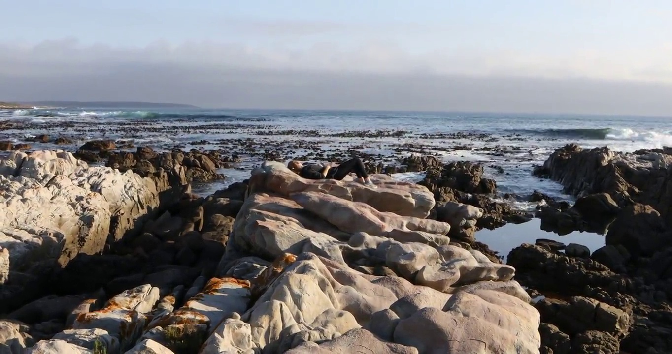 南非，德科尔德斯，一个十几岁的女孩躺在岩石上视频素材