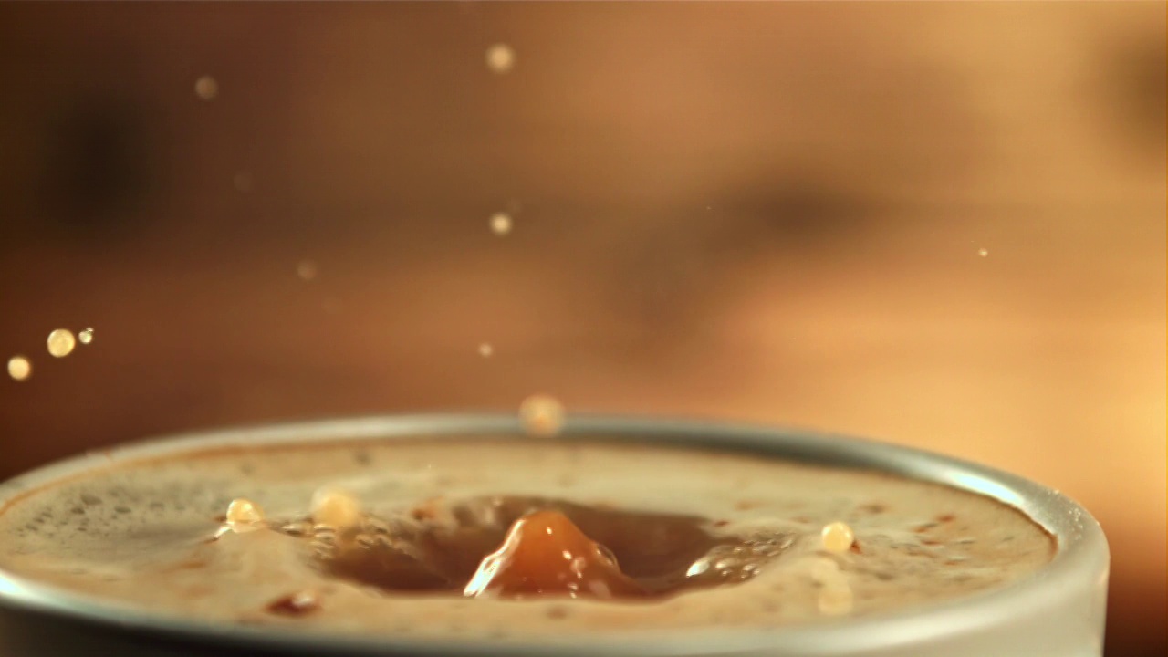 一滴牛奶掉进了一杯咖啡里，溅了一地。拍摄是慢动作1000帧/秒。视频素材