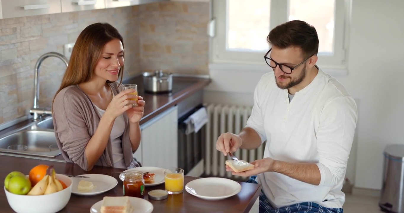 可爱的夫妇在厨房吃早餐，玩得很开心视频下载