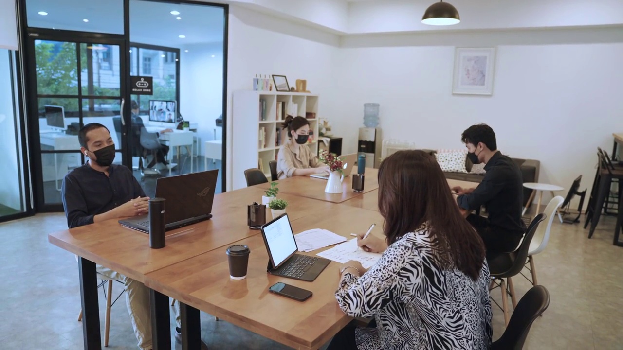 亚洲商务人士戴着口罩在办公室工作视频下载