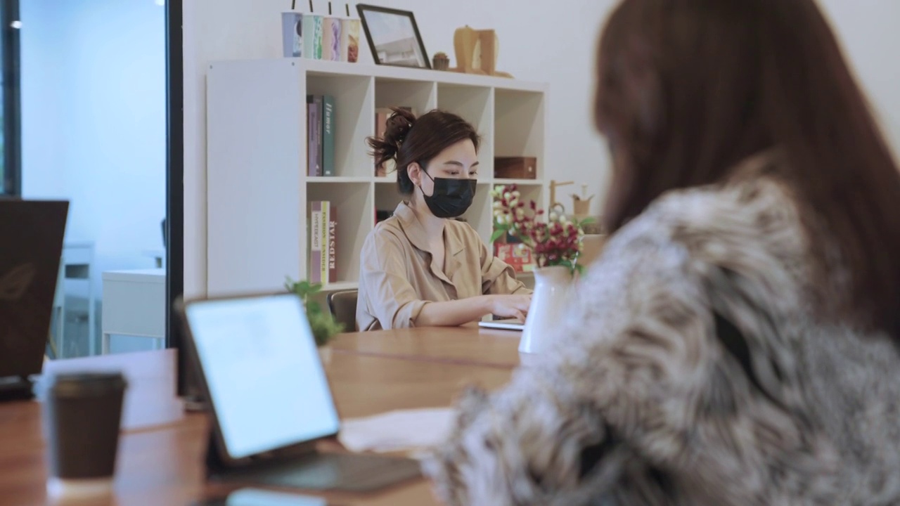 亚洲商务人士戴着口罩在办公室工作视频素材