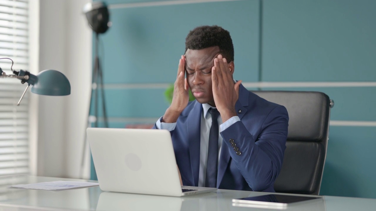 非洲商人使用笔记本电脑时头痛视频素材