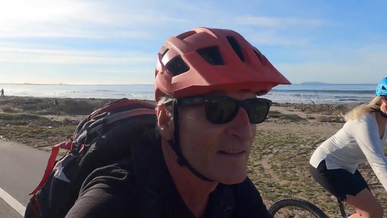 骑自行车的情侣沿着海岸的小路骑行视频下载
